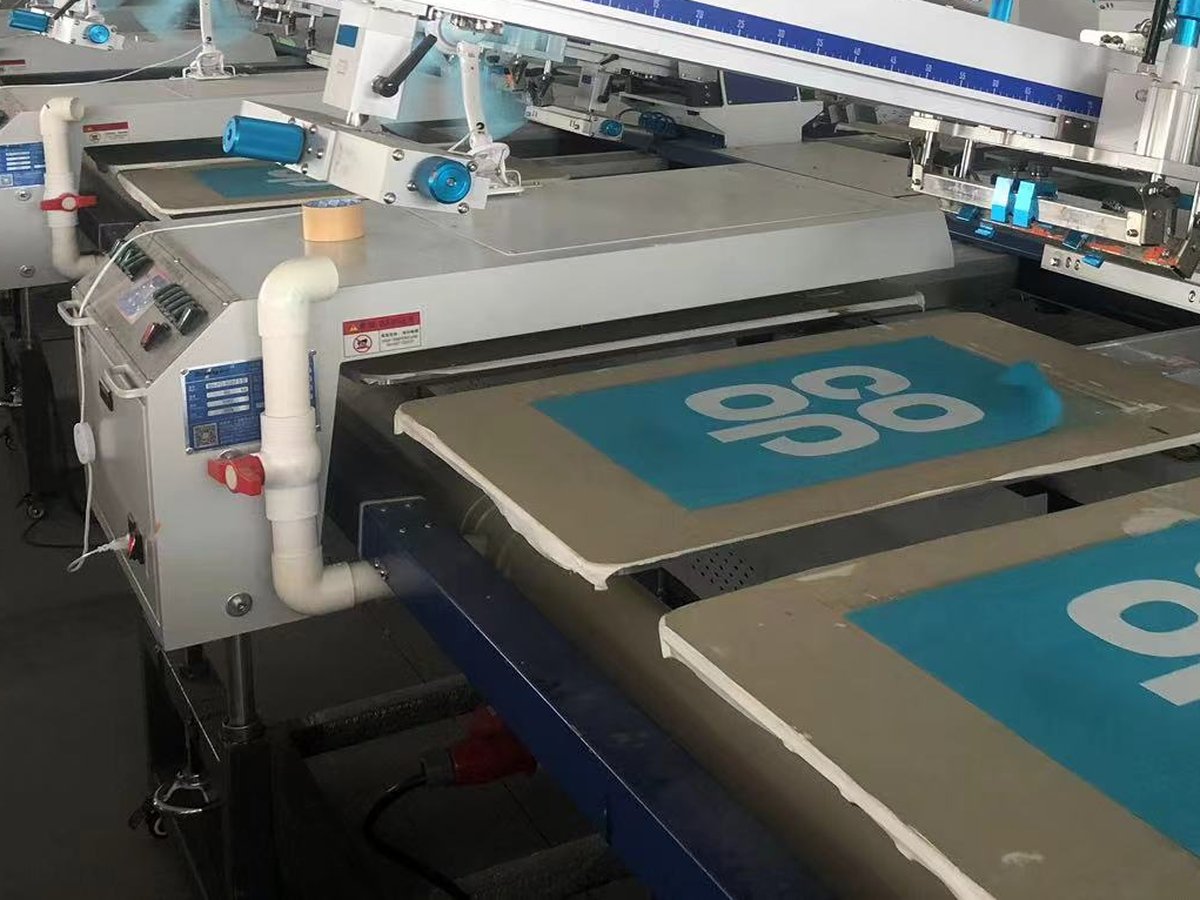 Automatic screen printing carousel applying a custom logo to fabric panels at the Weihuang factory